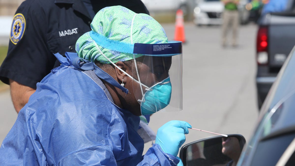 Shandrika Pritchett with the Walton County Health Department administers a COVID-19 test at a drive-thru testing station set up at the Van R Butler Elementary School on May 14 in South Walton County, Fla.