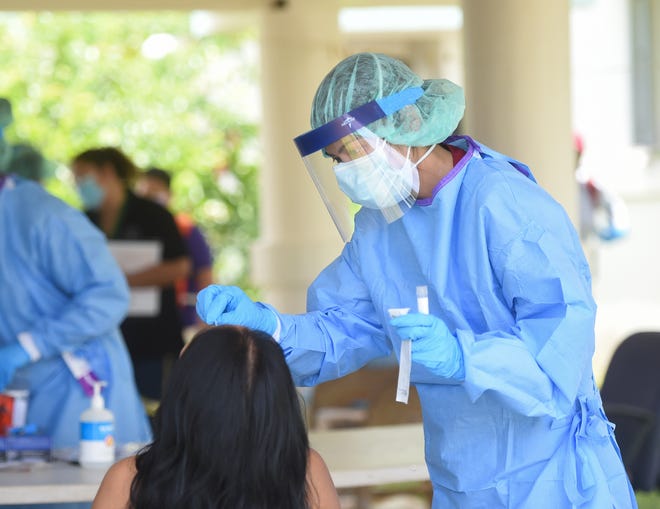 Public Health nurse Cassandra Suva administers a COVID-19 test on a GHURA public housing resident at in Agat, May 15, 2020.