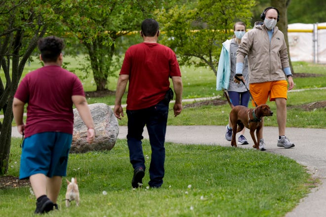 Park goers walk their dogs around Armstrong Park, Friday, May 15, 2020 in Lafayette.