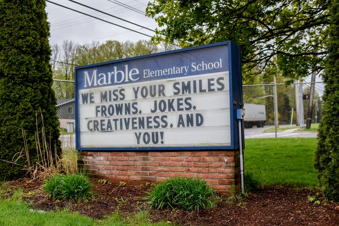 A sign displays a message from students at Marble Elementary School on Friday, May 15, 2020, in East Lansing. Parents dropped off books and picked up student belongings in the front of the school.