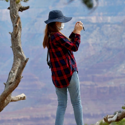 A visitor takes a photo at the Grand Canyon Friday