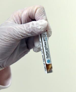 A vial of Pfizer’s mRNA COVID-19 Vaccine is prepared for first dosing at University of Maryland School of Medicine.