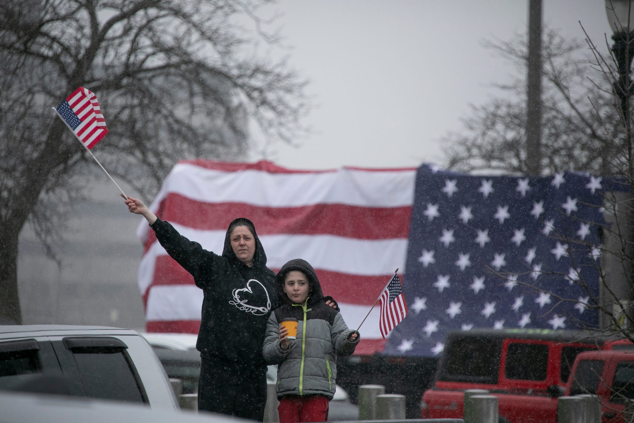 Renee Aldrich, left, and her son Gavin from Owosso join protestors as they block traffic around the Michigan State Capitol building in Lansing Wednesday, April, 15, 2020. "Gavin had his fourth grade trip to the Capitol last week that got canceled but we came anyway" said Renee Aldrich.