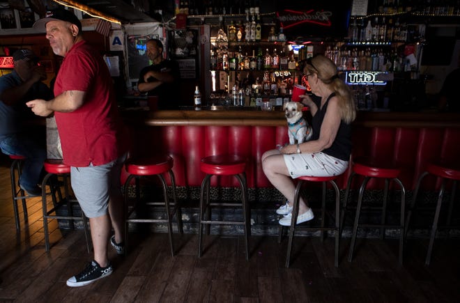 Red Barn owner John Labrano, left, stands as Ruth Ann Barshop of Indian Wells sits inside the bar in Palm Desert, Calif., on Saturday, May 16, 2020. The bar has been closed since mid-March when Gov. Newsom issued the state’s stay-at-home order to slow the spread of COVID-19.