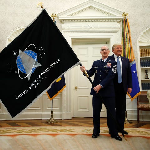 President Donald Trump stands as Chief of Space Op