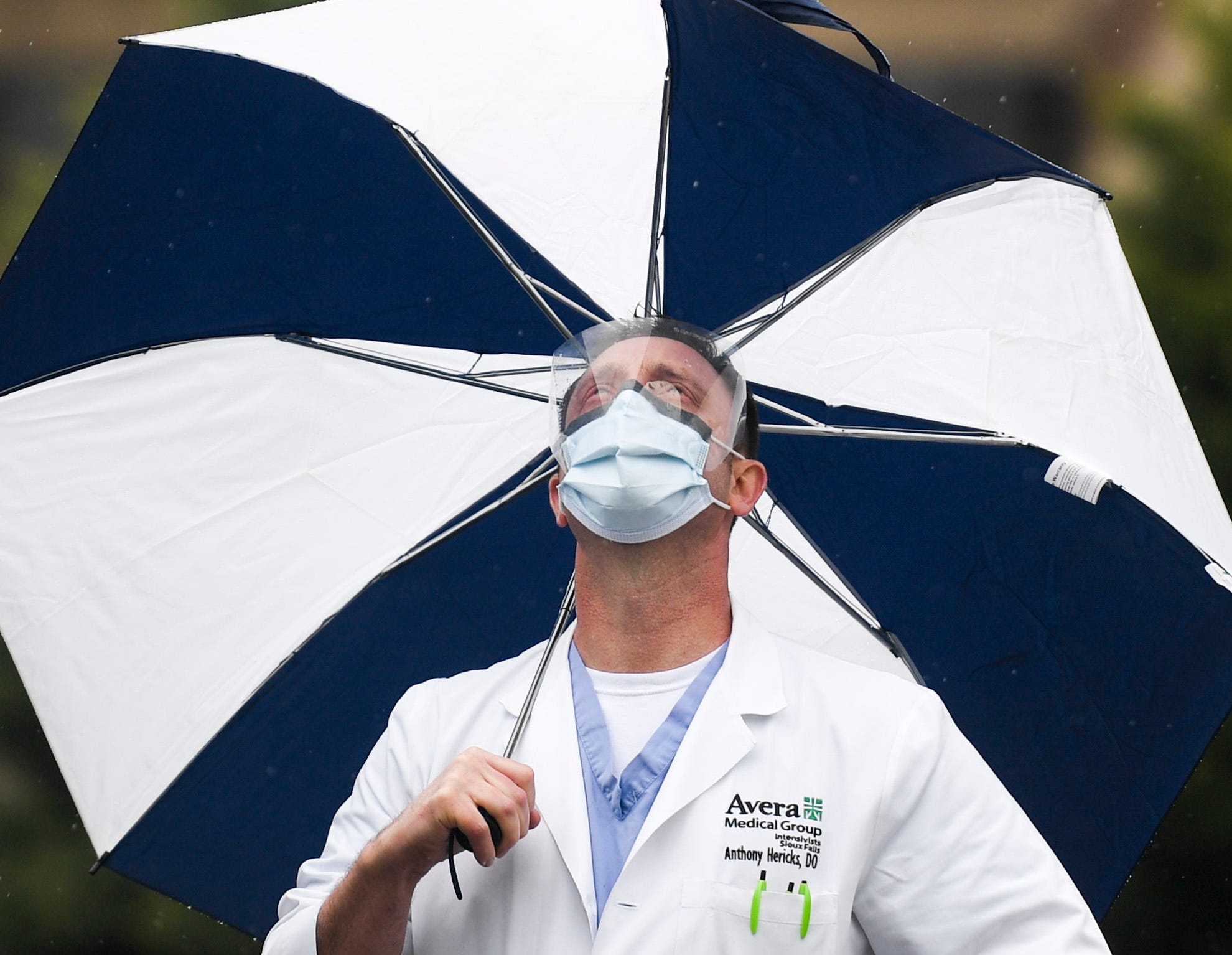 Dr. Anthony Hericks watches as South Dakota Air National Guard's 114th Fighter Wing flies over to honor healthcare workers during the coronavirus pandemic on Saturday, May 16, 2020 at Avera in Sioux Falls, S.D.