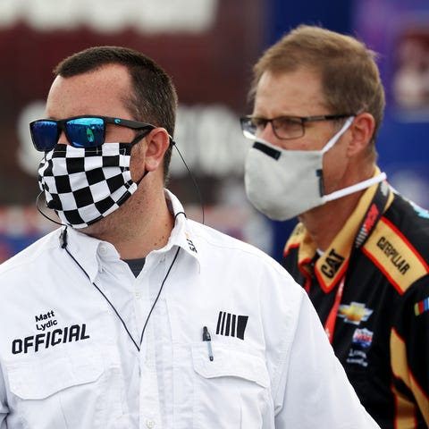 A NASCAR official with a mask looks on prior to th