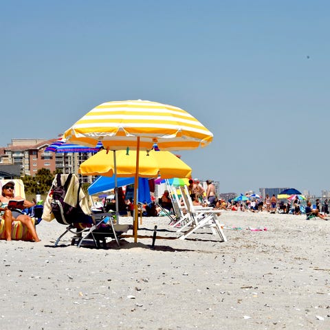 Visitors sit on the sand on Myrtle Beach, S.C., on