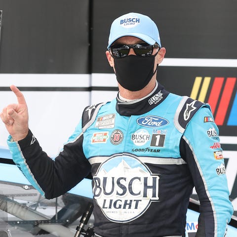A masked Kevin Harvick celebrates in an empty vict
