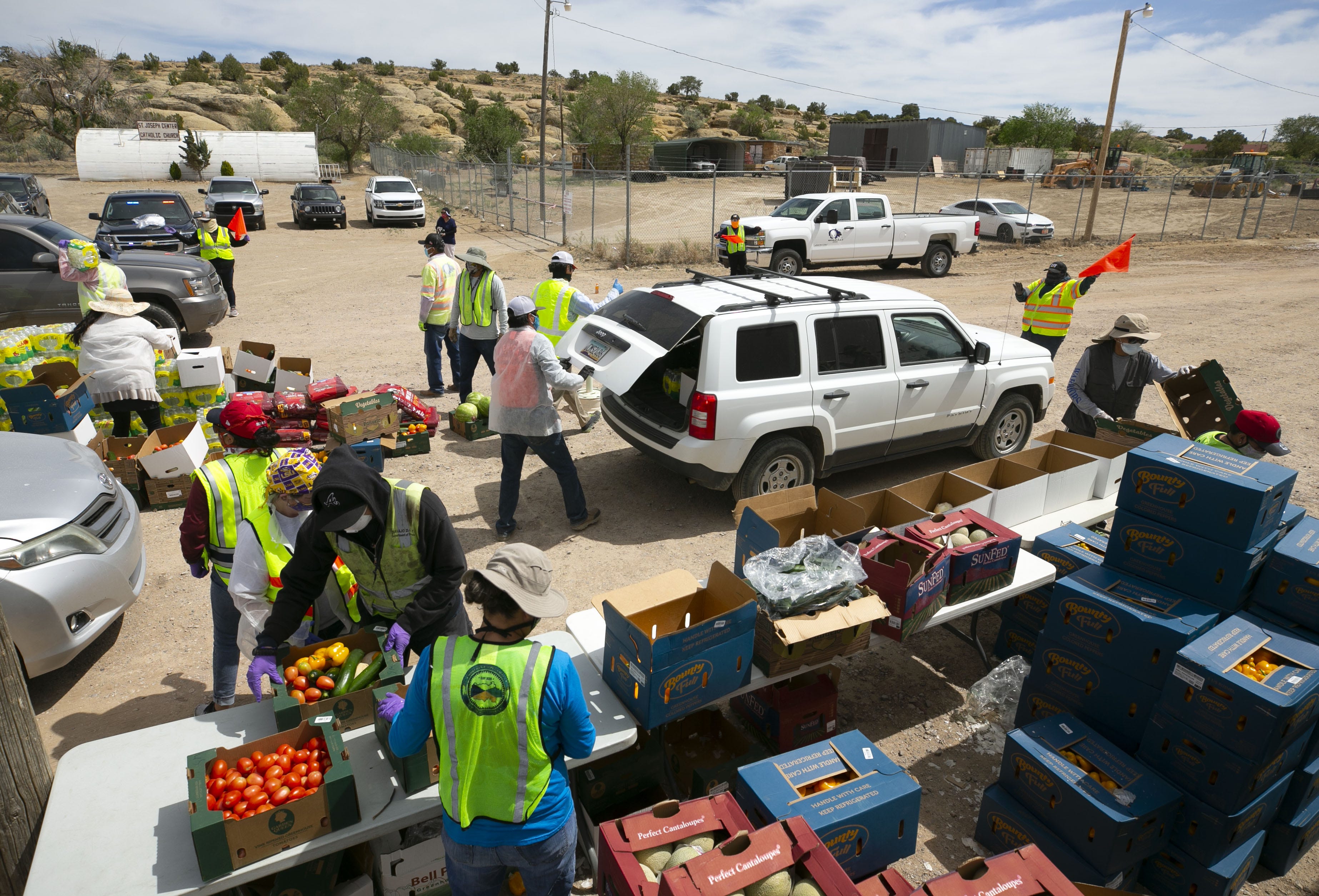 Volunteers, staff member of the Coyote Canyon chapter and the Navajo Nation Office of the President and Vice President, place fresh food, water and dog food into community members' vehicles at a food distribution point before the start of a weekend-long curfew in Coyote Canyon, New Mexico, on the Navajo Nation on May 15, 2020.