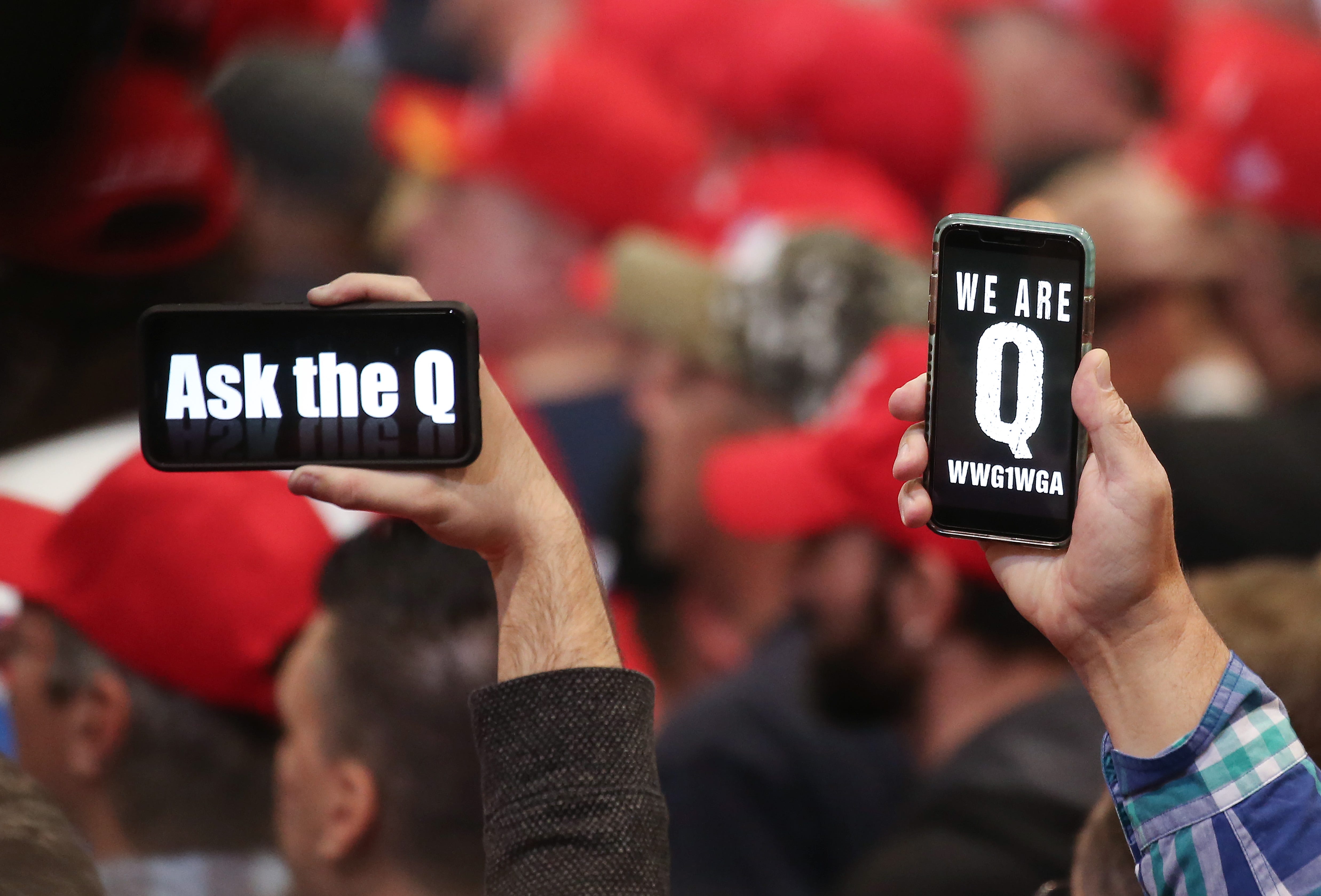 Donald Trump supporters hold up phones referring to the QAnon conspiracy theory at a campaign rally in Las Vegas on Feb. 21, 2020.