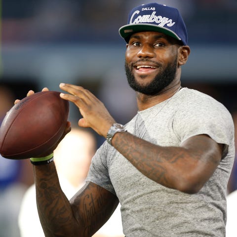 LeBron James throws a football on the sidelines at