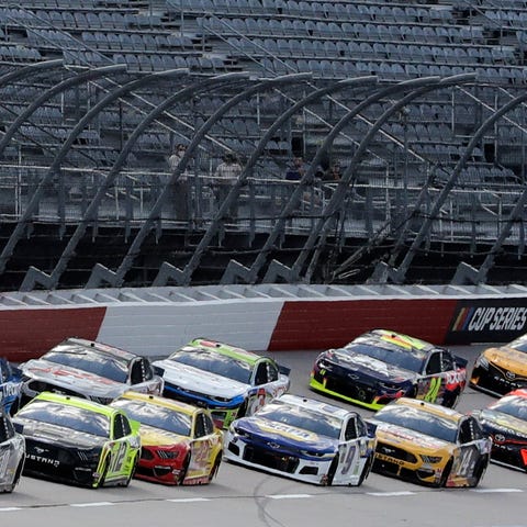 Cars approach the starting line in front of empty 
