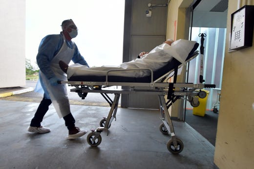 A patient with coronavirus is wheeled into a hospital in Agen.