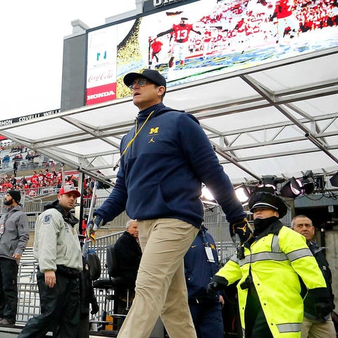 Michigan coach Jim Harbaugh walks on to the field 
