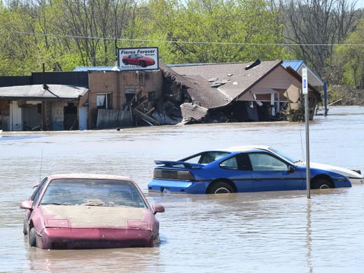 Fieros are submerged outside Fieros Forever, a business on the flooded out main street in the Village of Sanford after flood waters swept through the town.