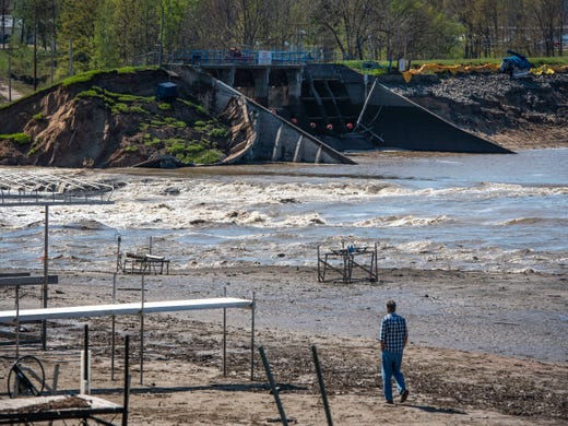 A man walks toward the Edenville Dam at Wixom Lake in Beaverton after the levees broke.