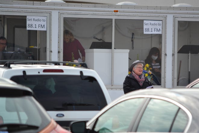The Rev. Annette Diamond preaches to a parking lot full of cars on May 17. Car horn beeps are the equivalent of shouts of “amen” in the outdoor worship service.