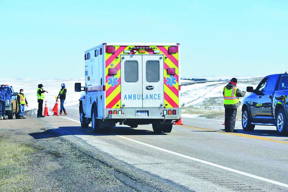 An ambulance is waved immediately through a highway checkpoint operated by the Cheyenne River Sioux Tribe. Tribal leaders say the checkpoints help control the flow of people onto and off of the reservation and gather critical health information to maintain the safety of residents on the reservation amid the COVID-19 pandemic.