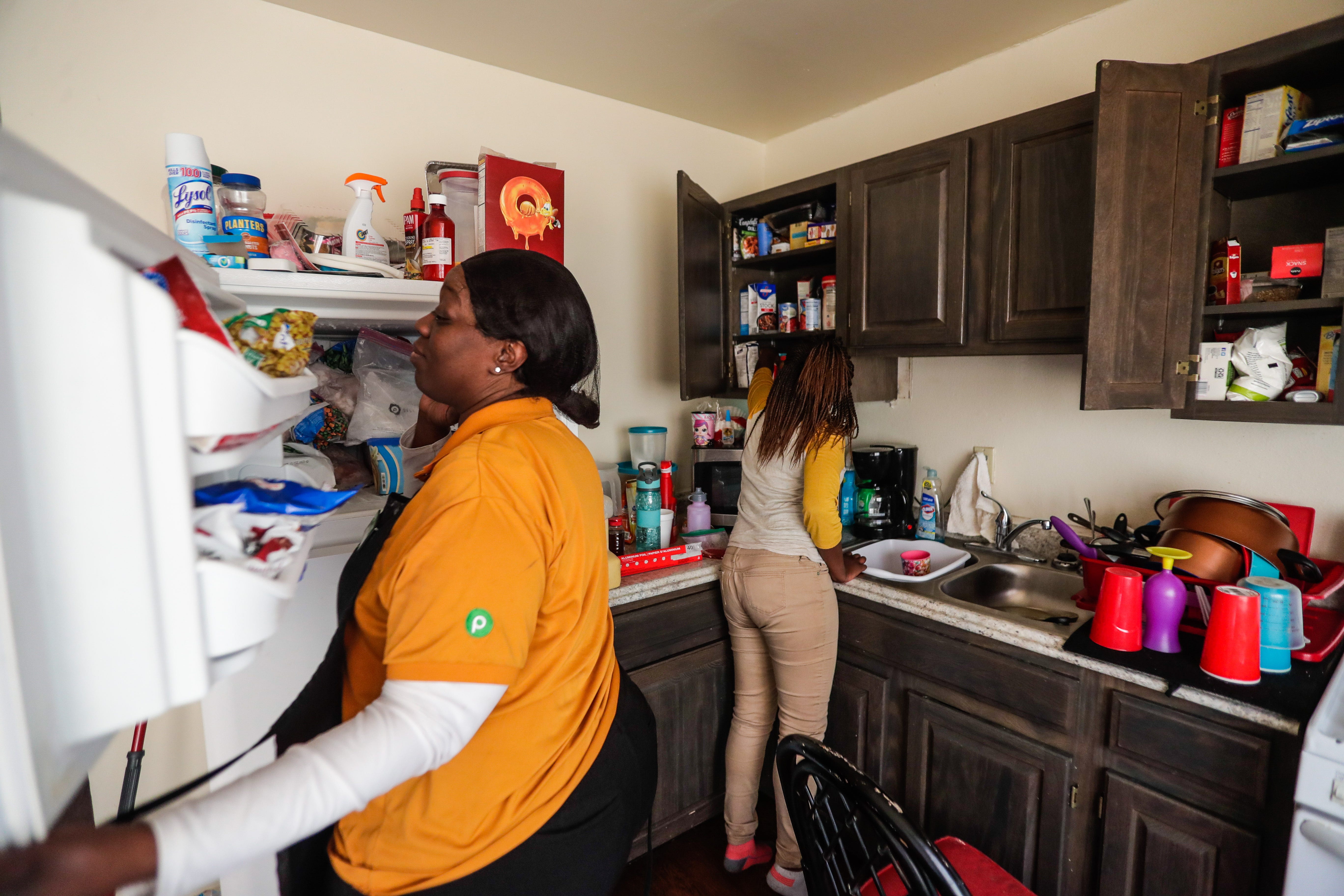 Kisha Simms, 38, and her daughter Deitra "DeeDee" Jackson, 11, look for afternoon snacks in their kitchen.