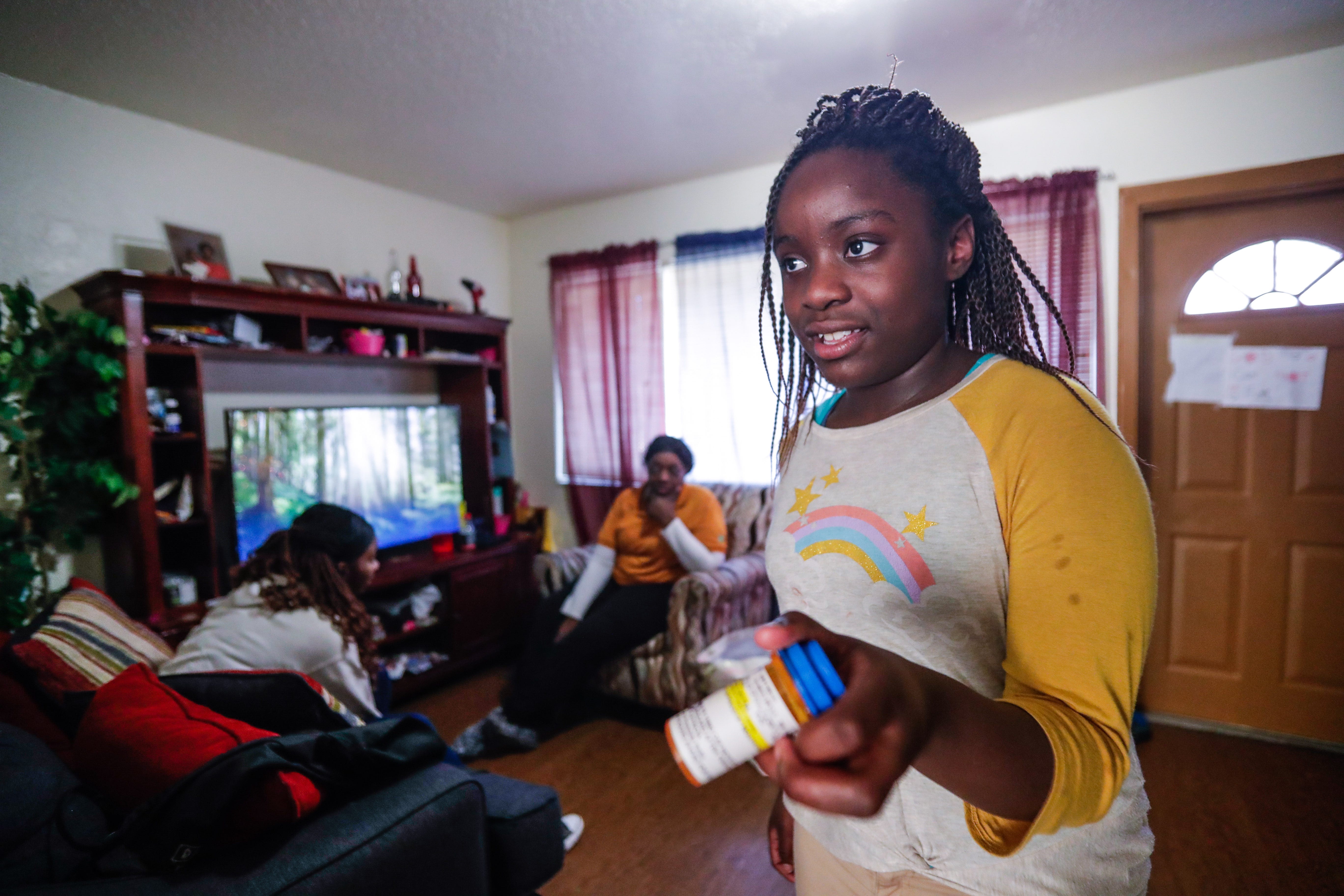 Deitra "DeeDee" Jackson, 11, shows what her prescription is that helps with her ADD. Both DeeDee and her older sister Lynaya Saylor, 18, have ADD.