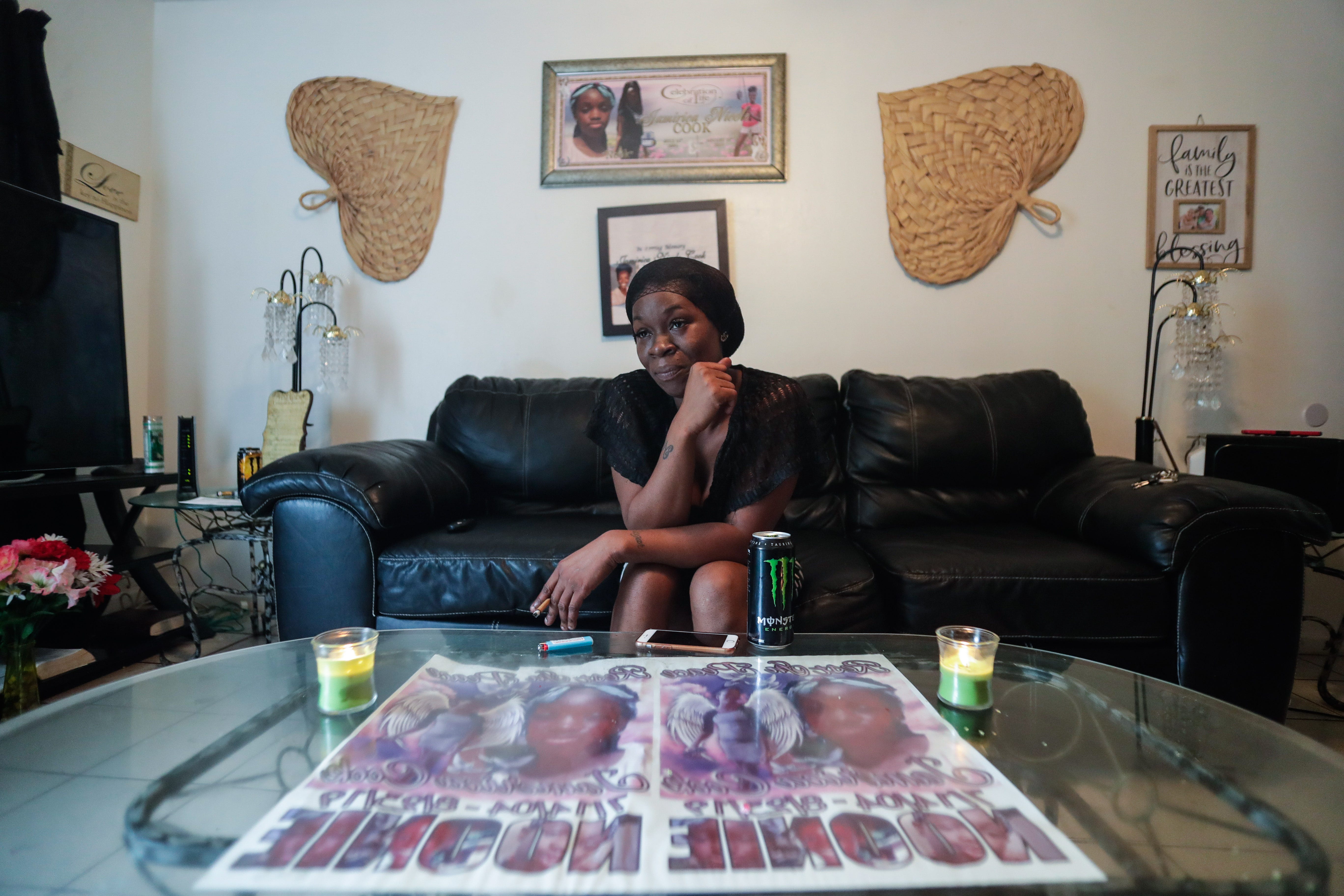 Koquisha Cook, 36, sits in her living room as she shares fond memories of her daughter Jamirica "Noonie" Cook, 15, who was shot and killed last year in her home in the Springfield Apartment complex. Photographs and tributes to Noonie decorate Cook's home.