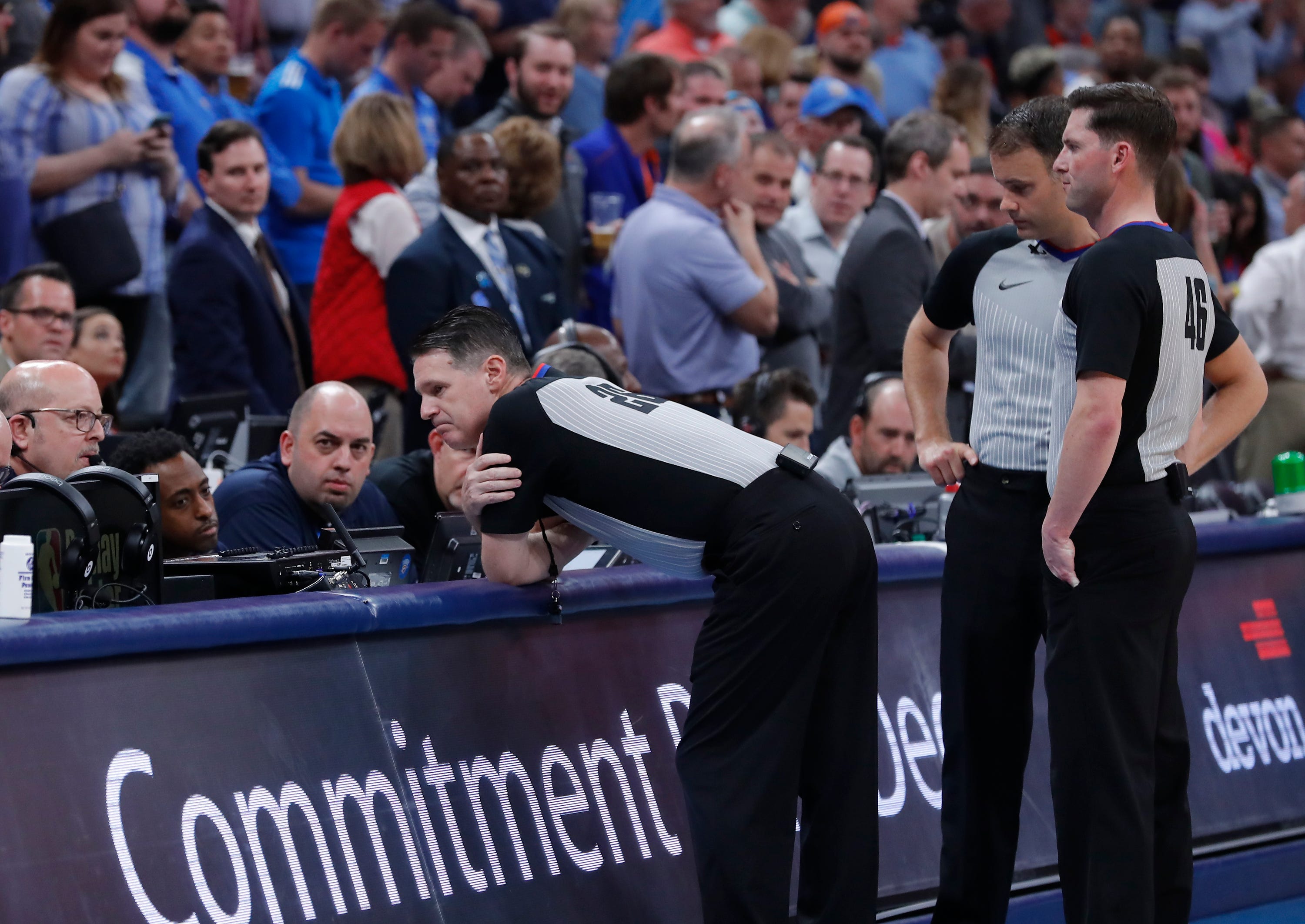 The NBA referees, including Mark Lindsay, stand at the scorer's table while awaiting instructions from the league after sending both the Jazz and Thunder to their locker rooms before tip off.