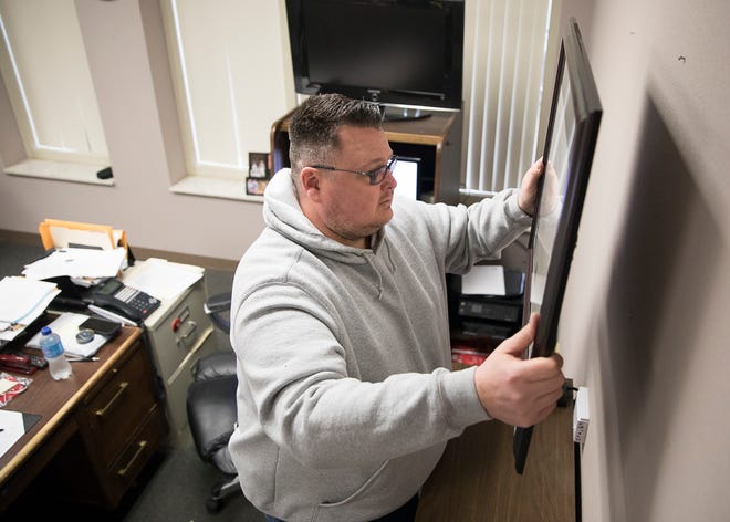 Former Chillicothe Chief of Police Keith Washburn finishes removing items from his wall as he gets ready for his new job as an assistant prosecutor for Jackson County. 