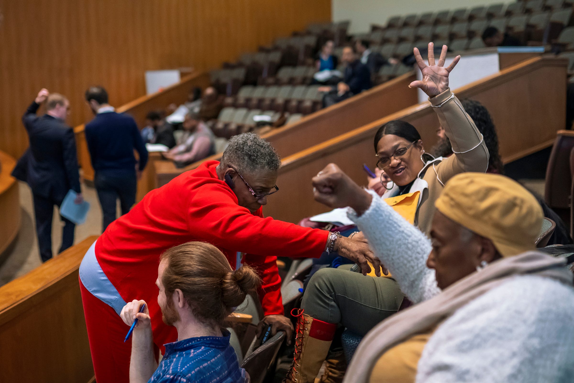 (Left to right) Charlevoix Village Association members Daisy Jackson, Marcia Kimble and CVA president Toyia Watts celebrate as Adam Schloff, director of development for Astral Weeks, walks back to his seat after he withdrew his firm's request seeking a brownfield tax abatement for a project in the Islandview neighborhood. "I was praising the Lord thanking him for all he's done for us, the city of Detroit. He turned the impossible into the possible," Jackson said. "It's not over with yet. We still have a fight. But it's a start. Maybe they'll listen to some of the community now."