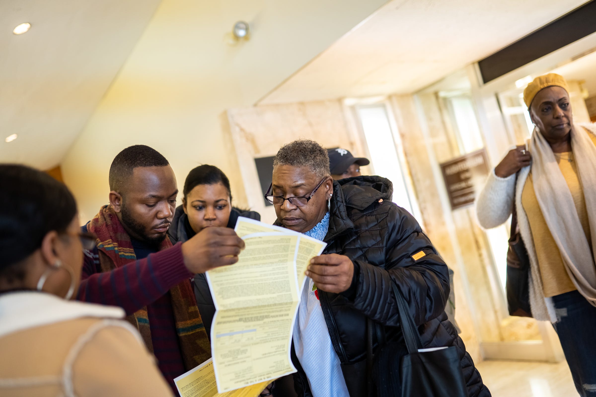 Barry Blackwell, director of community relations for Detroit City Council member Mary Sheffield, looks over paperwork with members of Charlevoix Village Association after a Detroit City Council meeting at the Coleman A. Young Municipal Center on Tuesday, Feb. 18, 2020.