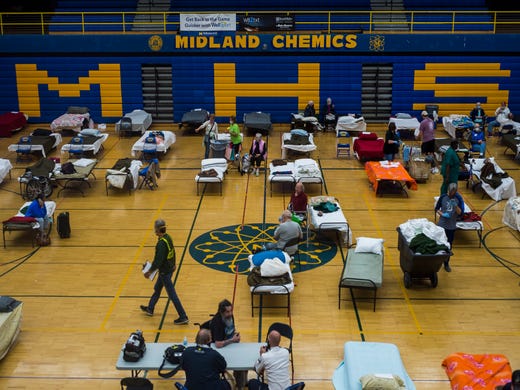 Volunteers assist evacuated residents at a temporary shelter at Midland High School, Wednesday.