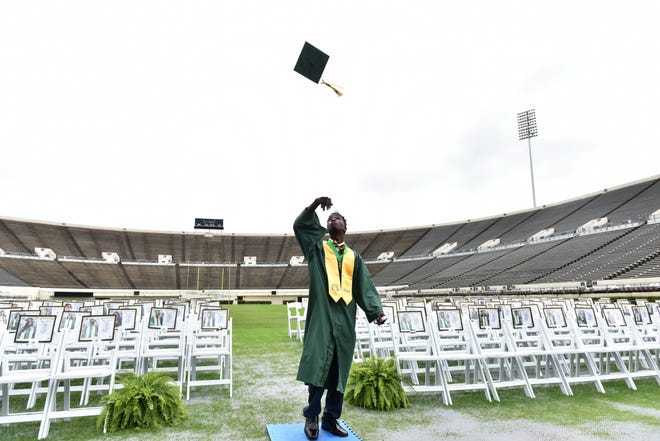 Jim Hill High School student Jonah Johnson tosses his graduation cap after getting his picture taken with his class at the Mississippi Veterans Memorial Stadium in Jackson in 2020.