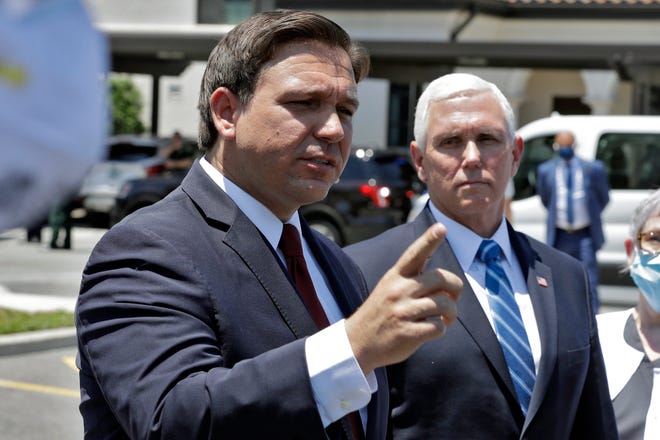 Florida Gov. Ron DeSantis, left, gestures as he speaks to the media with Vice President Mike Pence delivering personal protective equipment to the Westminster Baldwin Park, Wednesday, May 20, 2020 in Orlando, Fla.