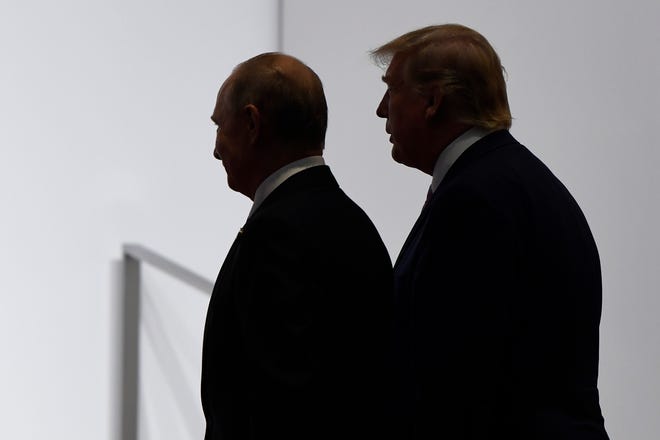 President Donald Trump, right, and Russian President Vladimir Putin walk to participate in a group photo at the G20 summit in Osaka, Japan, in June 2019.