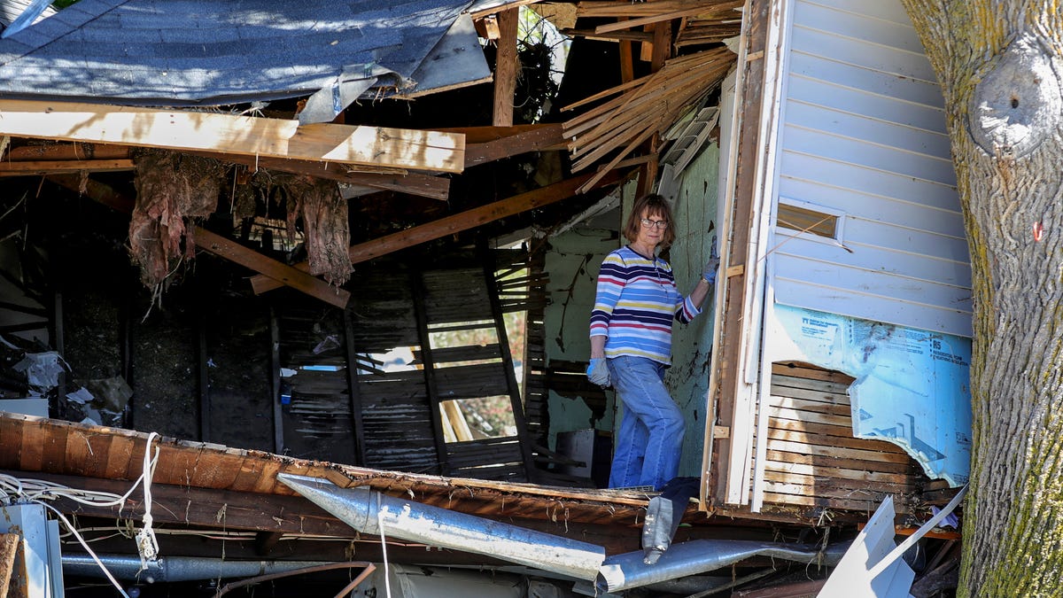 Linda Geiger goes through whats left of her Accounting and Tax business looking for records in Sanford Michigan Thursday, May 21, 2020.  The Sanford dam that held the Tittabawassee river failed causing massive flooding destroying homes and businesses. 