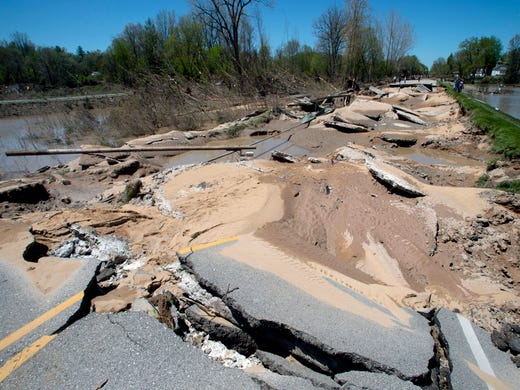 Chunks of asphalt rest broken apart after flood waters decimated the bridge in downtown Sanford, Mich., on Thursday, May 21, 2020. After dam failures upstream this week, water flooded the village, destroying homes and businesses, uprooting trees and crumbling bridges and infrastructure.