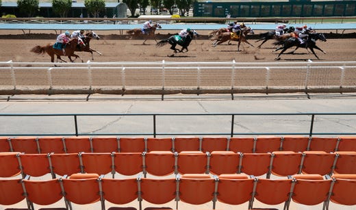 The field of quarter horses dash past empty stands Friday at Ruidoso Downs. The 2020 racing season is underway at Ruidoso Downs Racetrack in Ruidoso, N.M. after live racing was halted in mid-March because of COVID-19. The track is starting the season without fans in the stands due to the coronavirus.