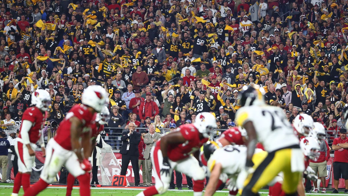 Steelers fans in the crowd wave yellow terrible towels against the Cardinals.