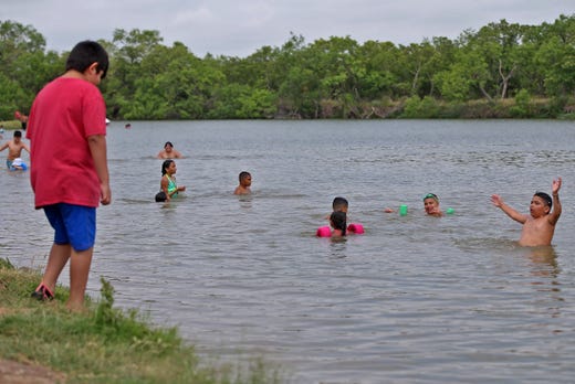 Young people play in the water at a recreation area at Lake Nasworthy during Memorial Day weekend on Saturday, May 23, 2020.