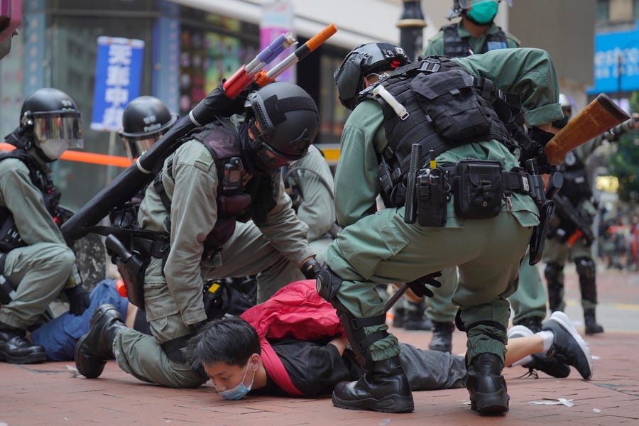 Riot police detain a protester during a demonstration against Beijing's national security legislation in Causeway Bay in Hong Kong on May 24. Hong Kong police fired volleys of tear gas in a popular shopping district as hundreds took to the streets to march.
