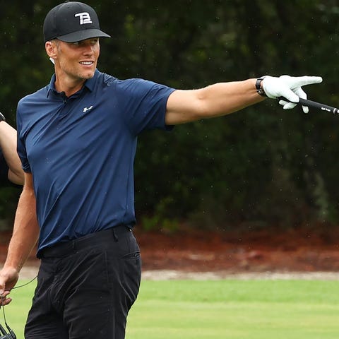 Tom Brady reacts after holing out from the fairway