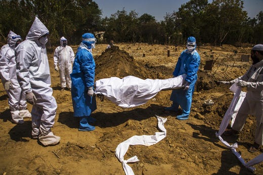 Indian health workers in hazmat suits bury a 55-year-old Muslim who died from the coronavirus, during Eid ul-Fitr, the Muslim festival marking the end of the holy fasting month of Ramadan, on May 25, 2020 in Delhi, India. Eid-ul-Fitr, considered one of the most important festivals in Islam, lacked its traditional fervor as religious gatherings remain banned in India as the country reels under a lockdown imposed by the government on March 25 to prevent the spread of coronavirus. Over 4,000 people have died and there have been over one hundred forty thousand infections so far.