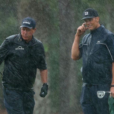 Phil Mickelson and Tom Brady react on the 13th gre