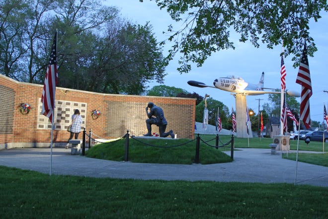 A person pauses at the Remembrance Wall at the Williams Park Veterans Memorial in Gibsonburg on Memorial Day.