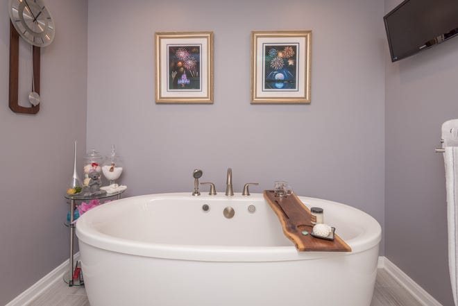 Kohler-bubbelbadkaret i denna Holly Springs-badrumsrenovering har däckmonterad hårdvara, inklusive en handspruta.