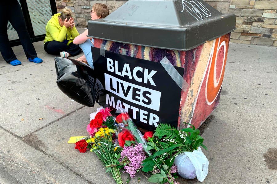 People gather around a makeshift memorial  May 26 in Minneapolis, near where a black man was taken into police custody before he died. The FBI is investigating the death. Video from a bystander showed a white officer kneeling on the man's neck during his arrest as he pleaded that he couldn't breathe.