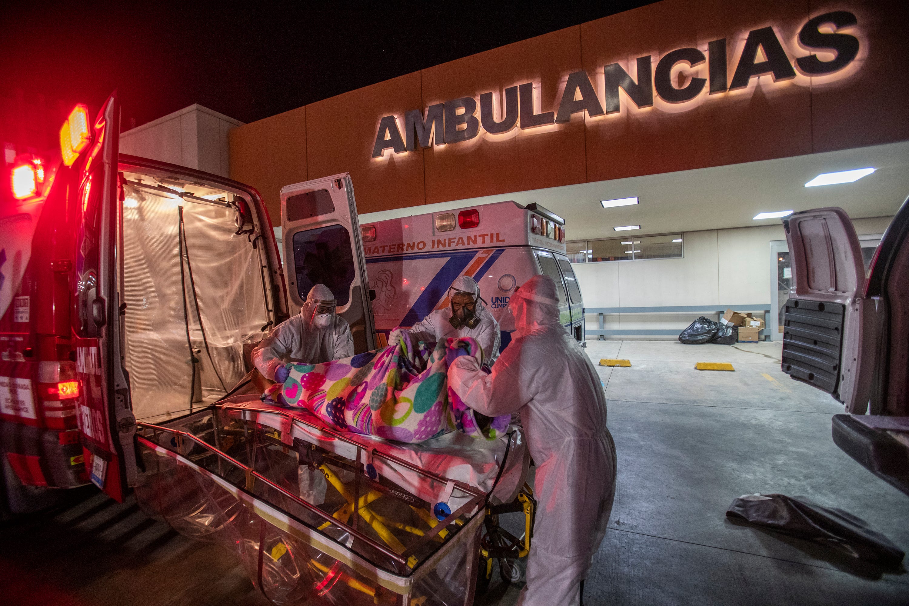 A deceased patient is moved from the COVID-19 response team's gurney to the coroner's gurney after the patient died during transport to the Mexicali General Hospital on May 24, 2020.