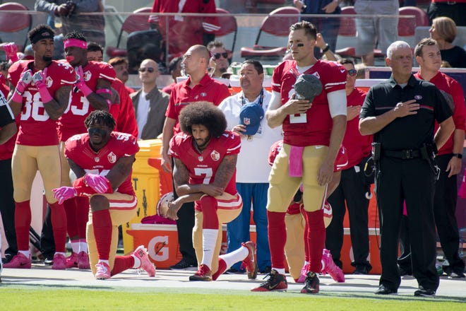 49ers quarterback Colin Kaepernick (7) kneels before an NFL game in 2016.