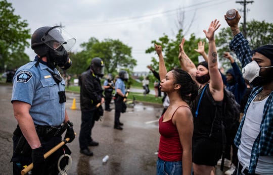 Protesters and police face each other during a rally for George Floyd in Minneapolis.