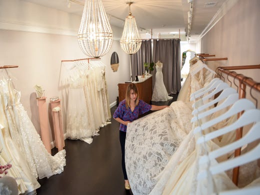Rachel Sweebe, the owner and stylist of Bridal Atelier in Montclair has had to switch to virtual consultations right the Covid-19 pandemic. Sweebe straightens dresses in the shop on Thursday May 28, 2020.